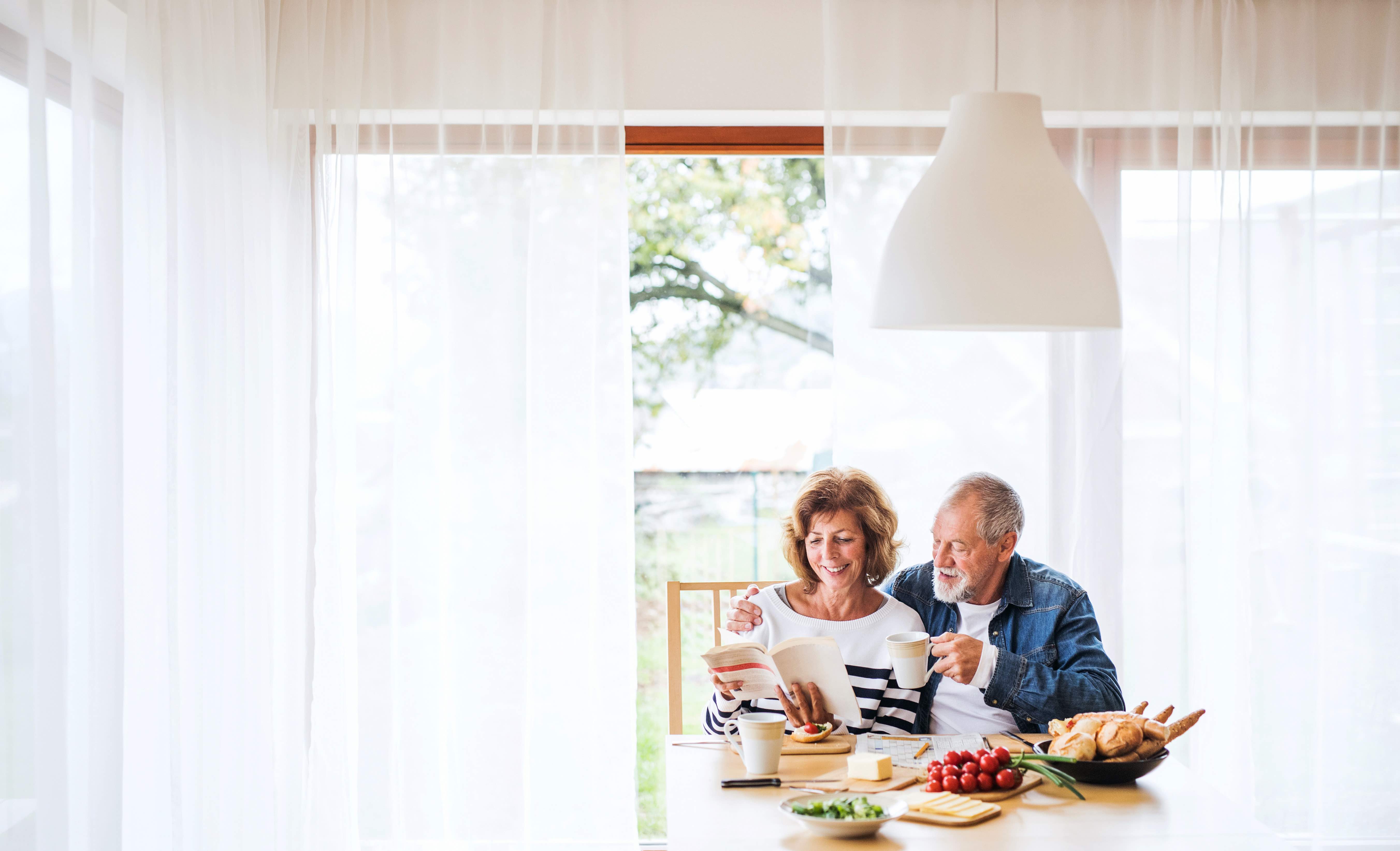 Senior couple eating breakfast at home.